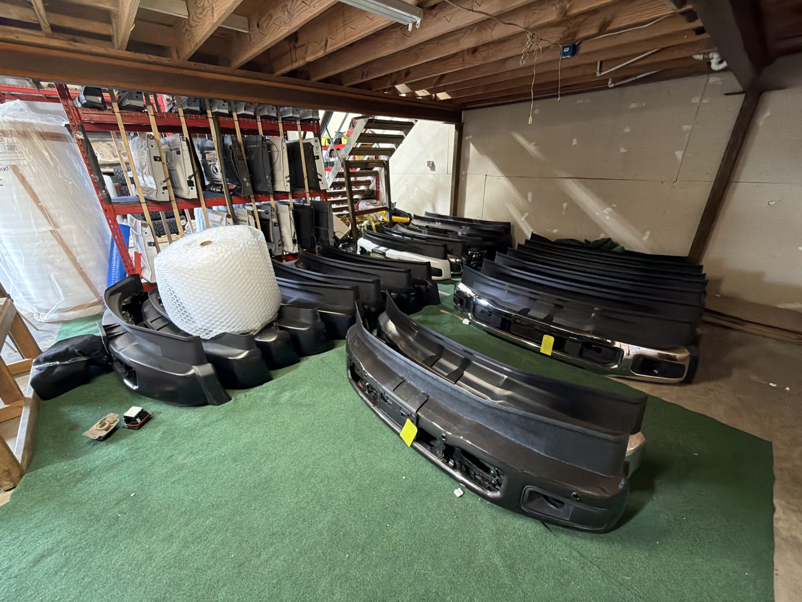 Factory OEM front bumpers on the floor ready for pickup at Texas Truck Parts warehouse